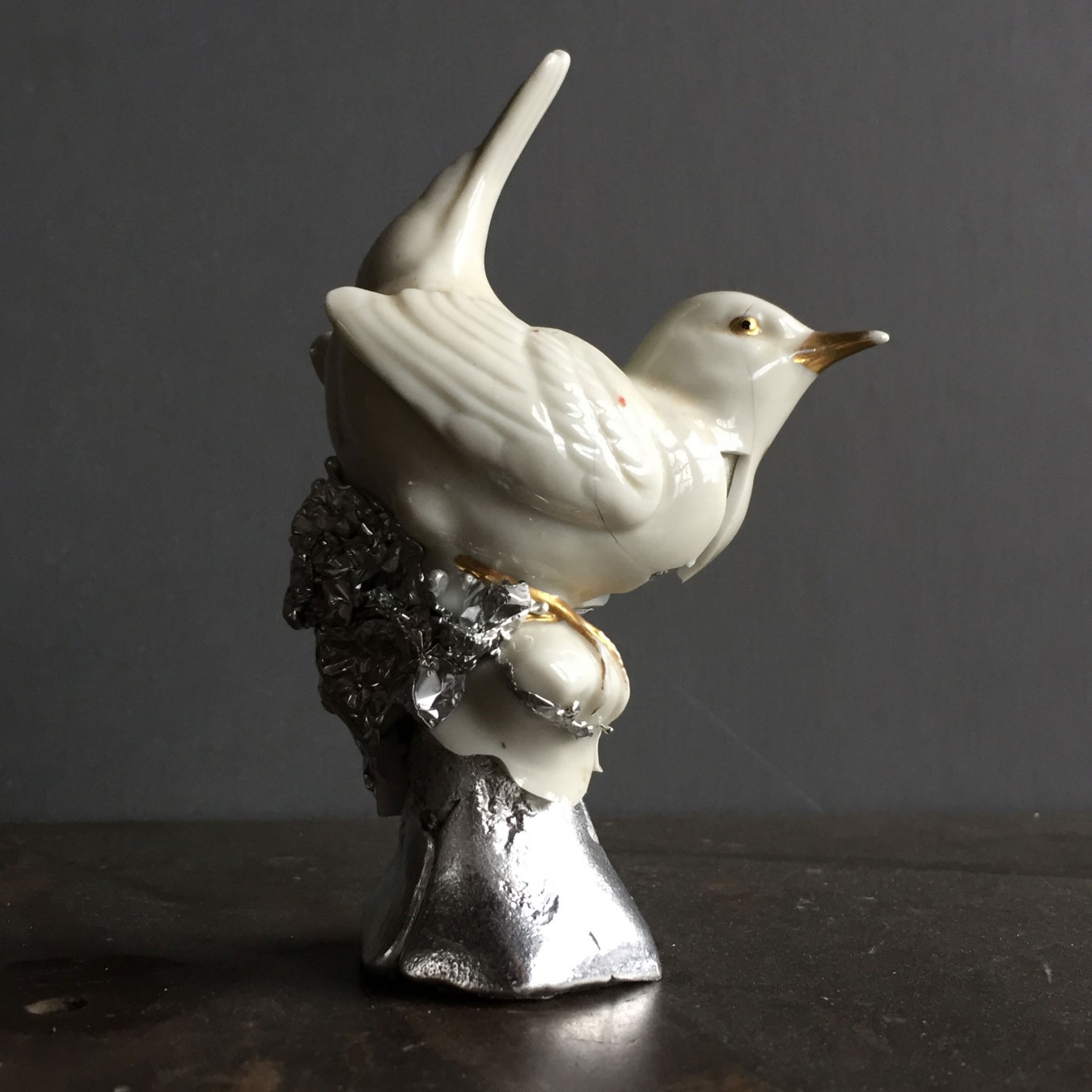 Image of a small ceramic wren bird. Used as a mould and showing the collision of 2 materials coming together. Hammered to open up and expose the cast pewter core