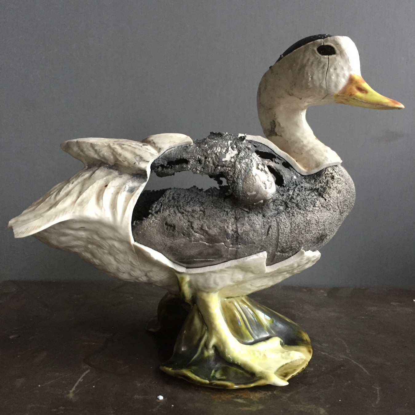 Image of a ceramic duck that is cracked and broken because molten pewter was poured into it as it is slipcast