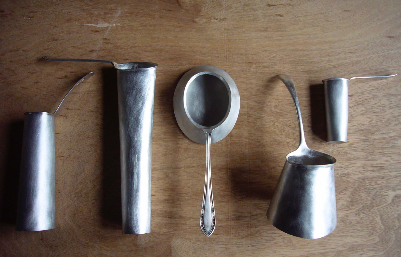 Image of a series of very deep spoons that suggest a jug, vase or vessel